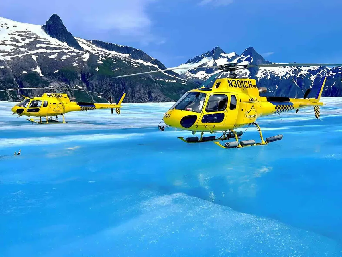 Helicopter parked on the ice with visitors walking the surface on a Juneau helicopter glacier landing tour